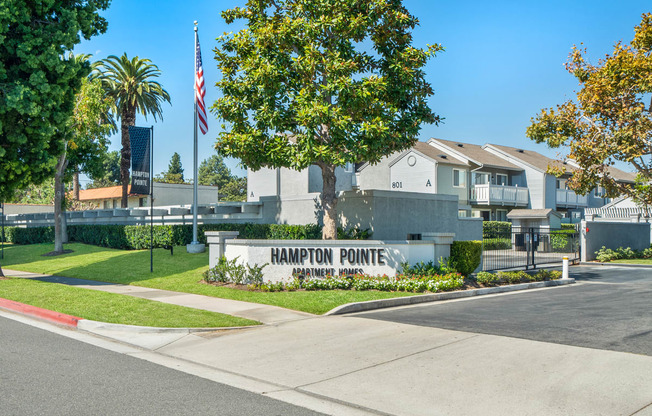 a sign for the pointe neighborhood with houses in the background