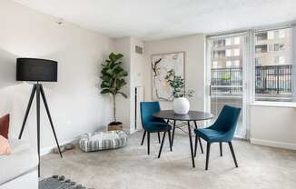 a living room with a table and chairs and a window