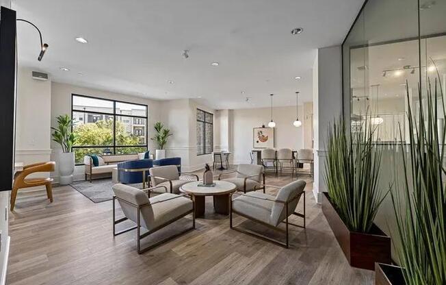 A modern living room with a glass wall and a large window.