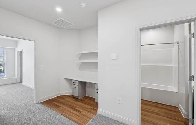 A white room with a desk and drawers.