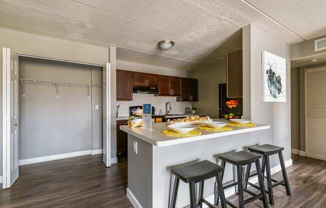 A kitchen with a bar stool and a fridge.