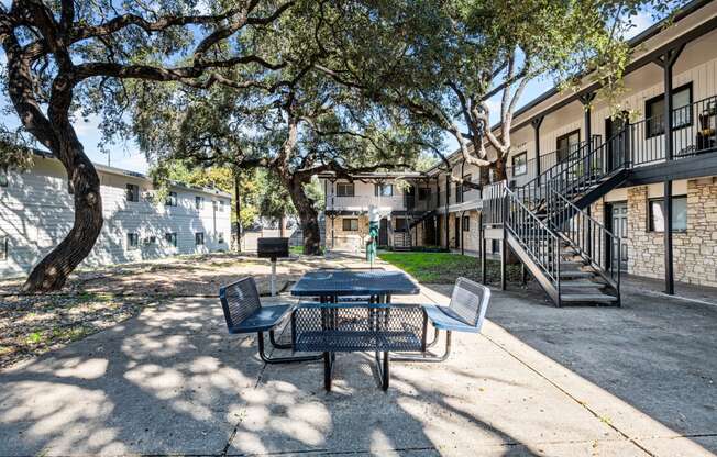 our apartments have a patio with a table and chairs and trees