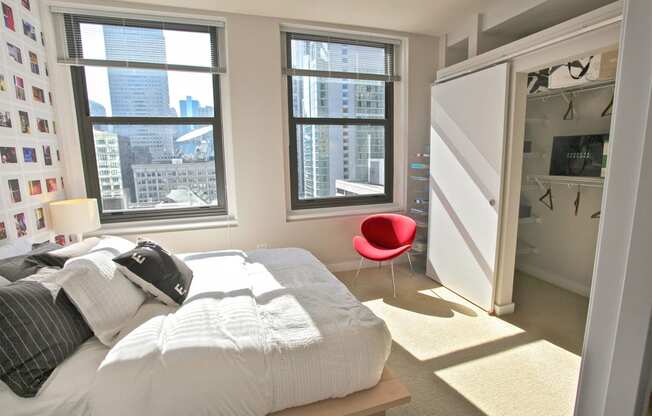 a bedroom with a bed and a closet and three windows