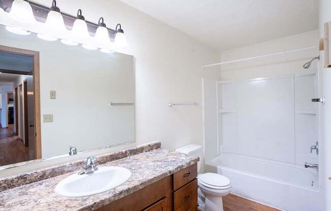 A bathroom with a sink, toilet, and bathtub. Fargo, ND Park Place Apartments