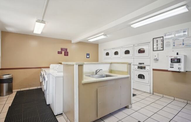 a kitchen with a sink and washes and dryers in it