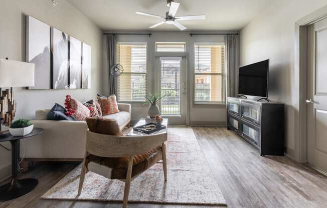 a living room with hardwood floors and a ceiling fan