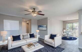 A living room with a white couch and a ceiling fan.