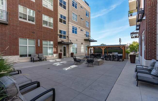 an outside patio with tables and chairs and a brick building