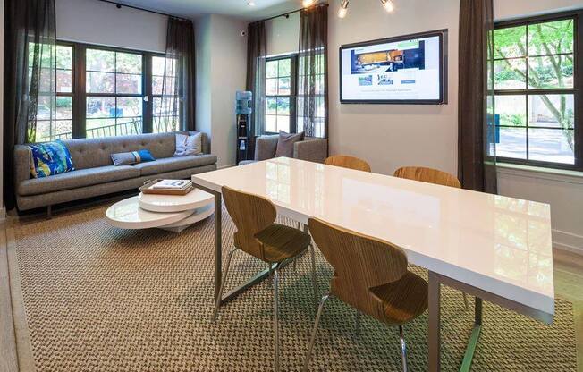 A modern dining room with a white table and chairs.