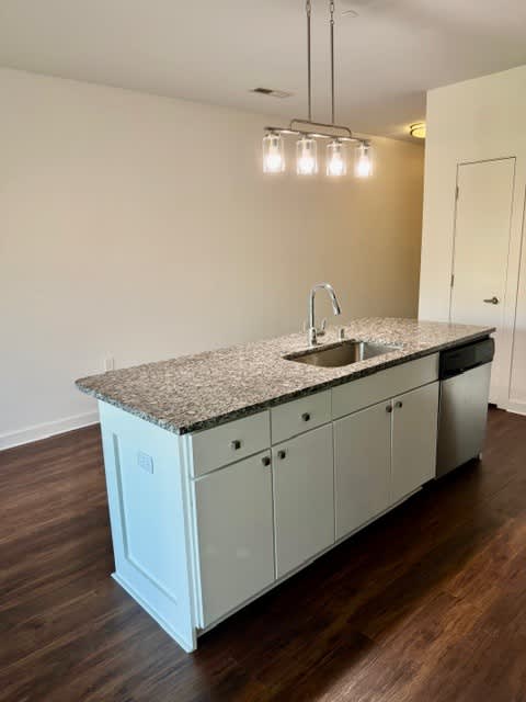 A kitchen with a granite countertop and a sink.