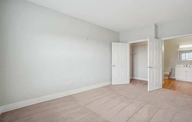 A room with a carpeted floor and a doorway leading to another room.