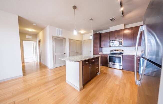 a kitchen with wood flooring and stainless steel appliances