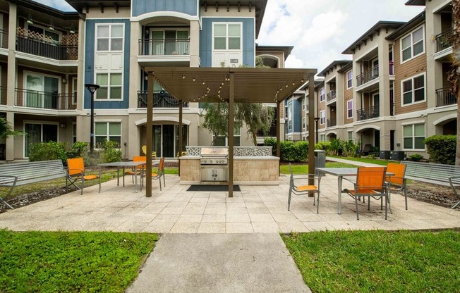 a large patio with a fire pit in front of an apartment building
