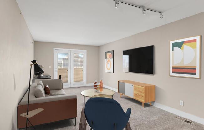 a living room with beige walls and a flat screen tv on the wall