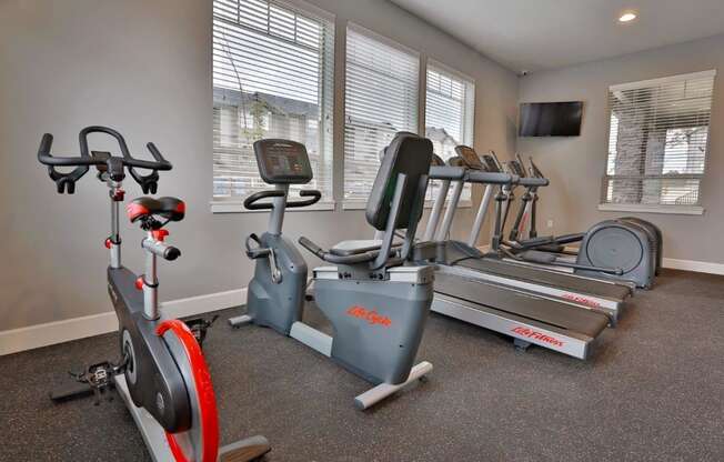 a home gym with exercise equipment and windows