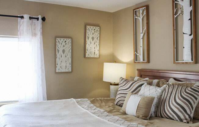 a bedroom with a large bed and three mirrors on the wall