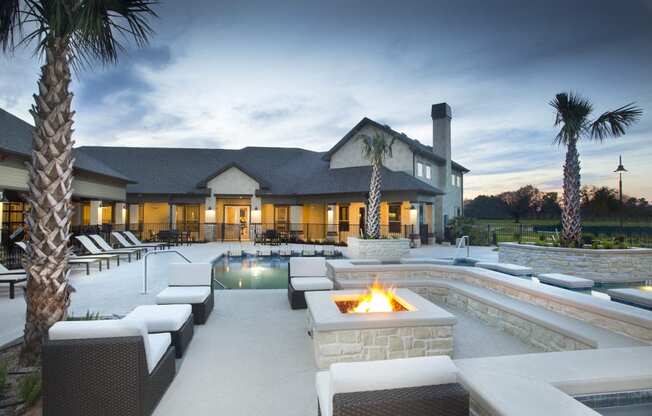 a swimming pool with a fire pit in front of a house