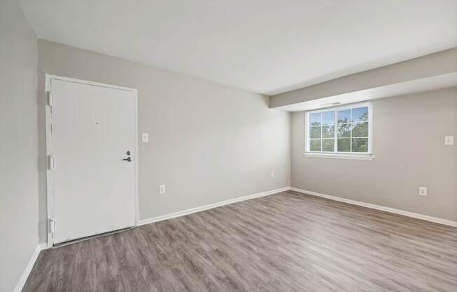 an empty bedroom with a door and a window at ReNew Odenton