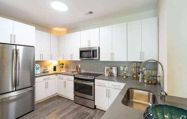 A Kitchen With White Cabinets at The Aster Apartments, North Carolina
