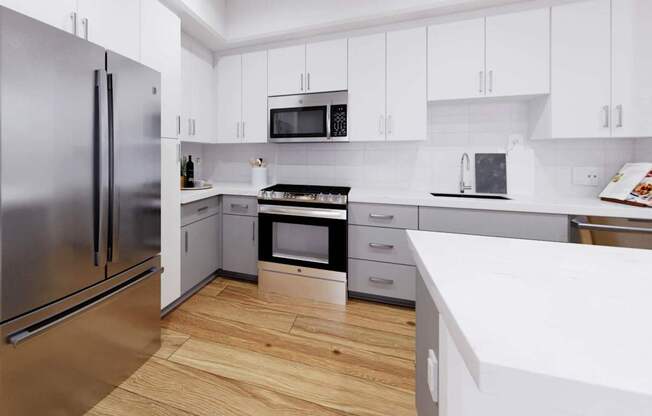 A modern kitchen with a refrigerator, oven, microwave, and sink at The Villas at Anacapa Canyon, Camarillo, 93012