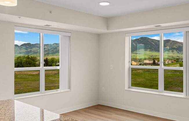 A room with a view of a mountain range through the windows.