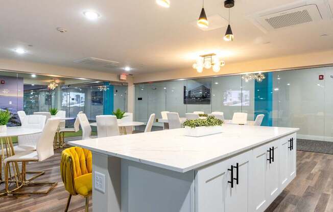 a meeting room with a large white counter top and chairs and tables