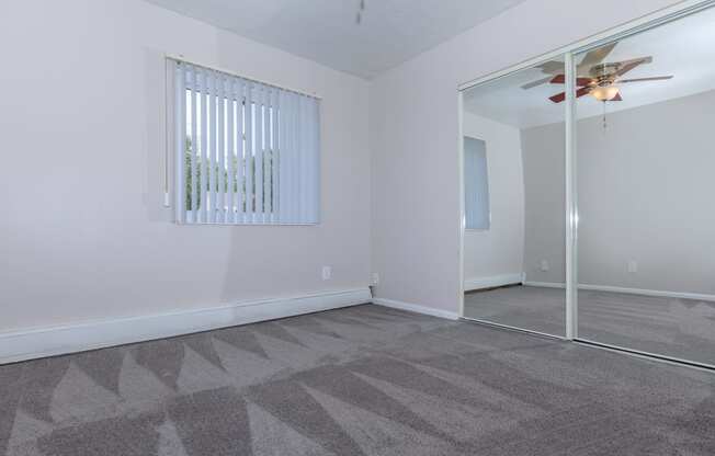 a bedroom with a mirror and a ceiling fan