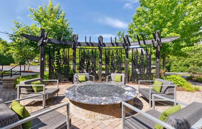 an outdoor patio with a fire pit and lounge chairs