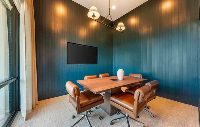 A conference room with a large table and chairs.