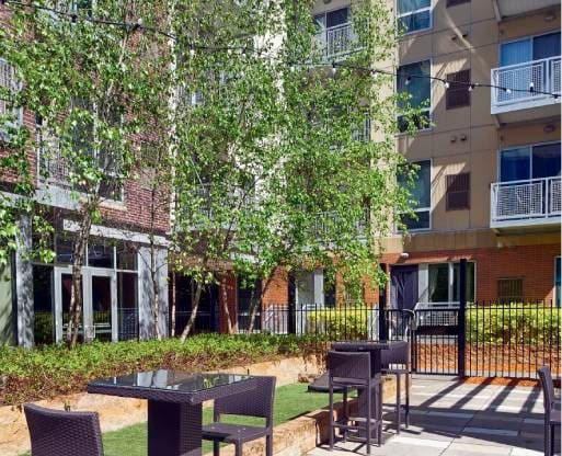 A patio with a table and chairs is in front of a building.