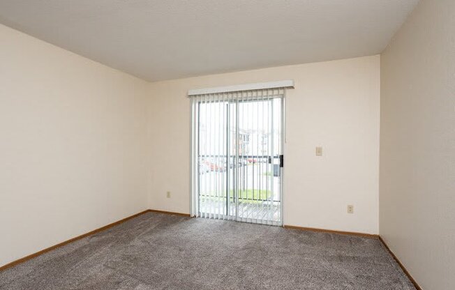 an empty living room with a sliding glass door