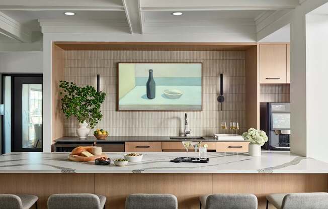 A modern kitchen with a large island and grey bar stools.