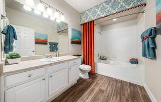A bathroom with a white toilet, sink, and bathtub.