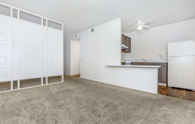 A white kitchen with a fan on the ceiling.