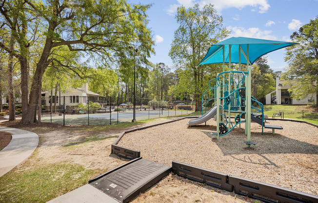 a playground with a swing set and a slide in a park