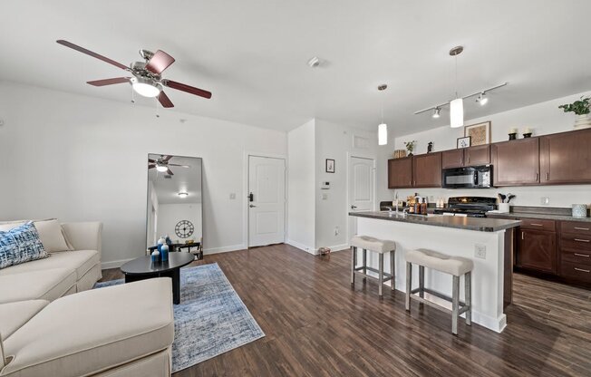 A modern kitchen with white cabinets and a wooden floor.