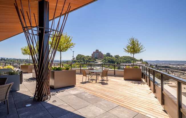 a roof deck with tables and chairs and a view of the city