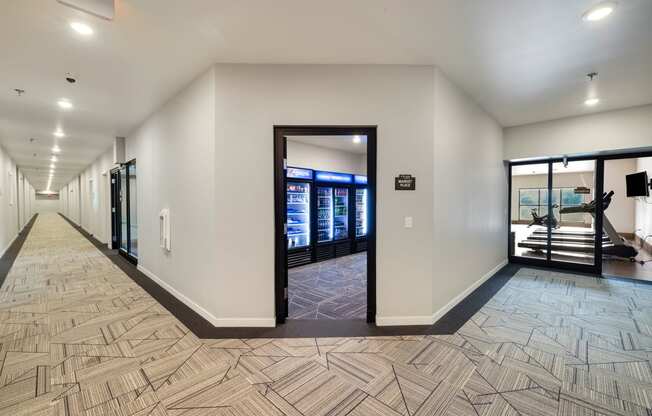 a long corridor with doors and vending machines in a building