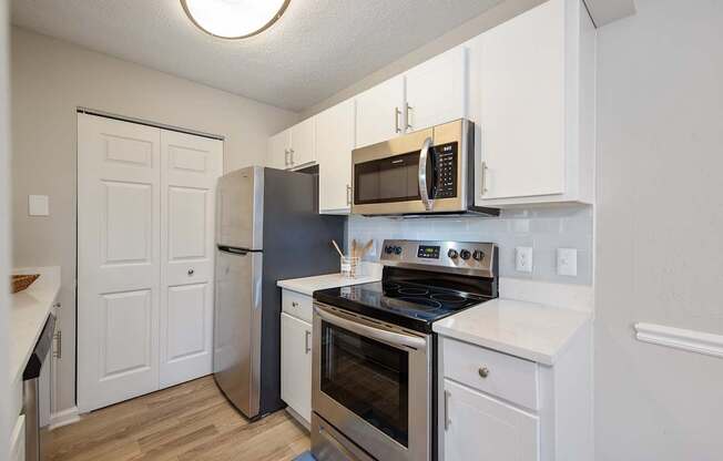 A kitchen with white cabinets and a black stove top.