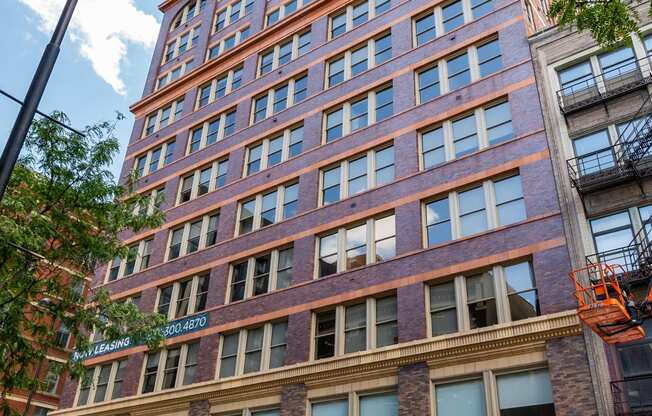 a tall brick building with cars parked in front of it