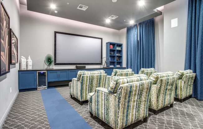 a theater room with chairs and a television on the wall