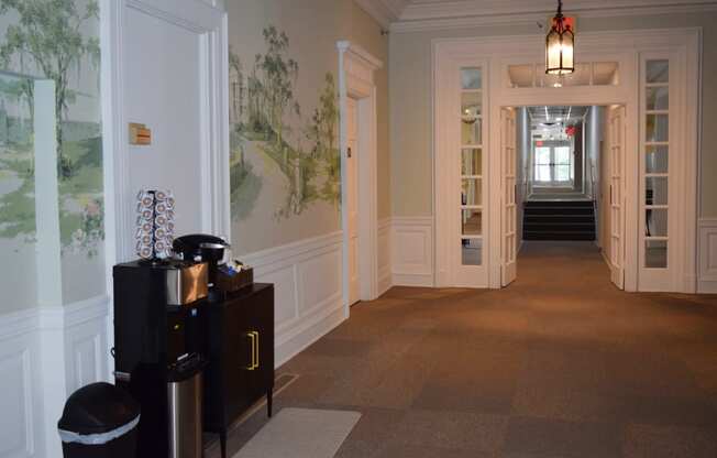 a hallway with a painting on the wall and aoyer with doors and a staircase