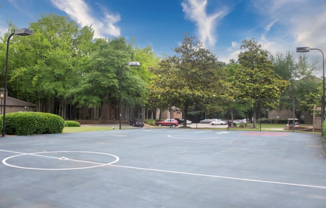 a basketball court in a park with trees at The Summit Apartments, Tennessee