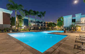 Community Swimming Pool with Pool Furniture at Madison Park Apartments located in Anaheim, CA.