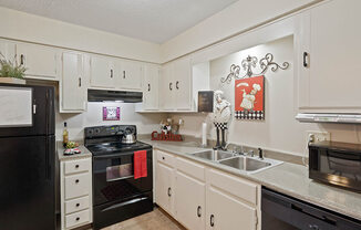 a kitchen with black appliances and white cabinets