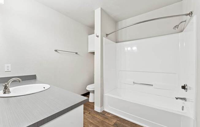 A white bathroom with a sink, toilet, and bathtub.