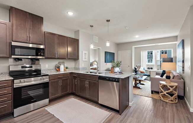 A modern kitchen with dark wood cabinets and stainless steel appliances.
