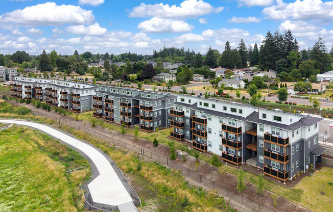 A large apartment complex with a curved walkway in front.