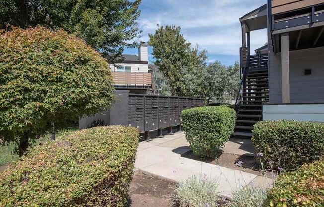 A building with a staircase and a hedge at Sierra Glen Apartments, California, 95621