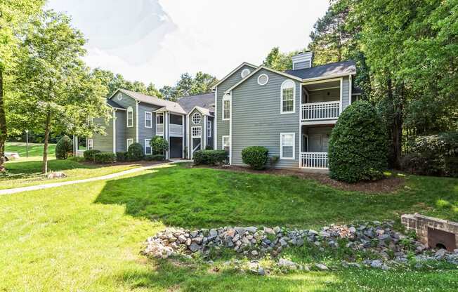 the front yard of a house with a lawn and trees